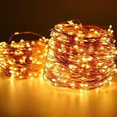 some lights that are on top of a white table and one is brown with orange string lights