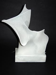 a white sculpture sitting on top of a black table