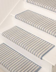 the stair treads are lined with blue and white striped rugs on each step