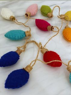 multicolored tasselled ornaments are tied together on a white tablecloth with twine