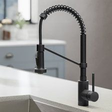 a black faucet on the side of a kitchen sink