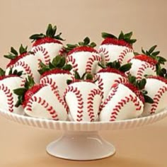 a white platter filled with strawberries on top of a table