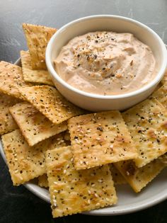 a white plate topped with crackers and dip