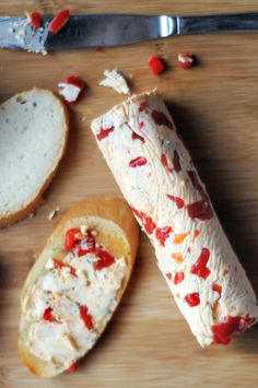 some bread with cheese and sauce on it next to a knife, spoon and pepperoni