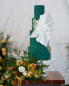 a green and white wedding cake with flowers