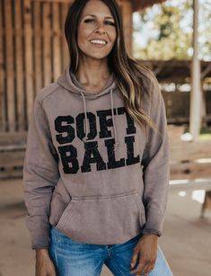 a woman wearing a sweatshirt that says soft ball