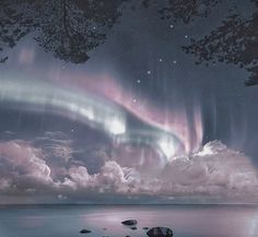 the aurora bore is shining brightly in the night sky over water and rocks on the shore