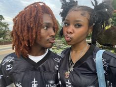 two young people with dreadlocks standing next to each other