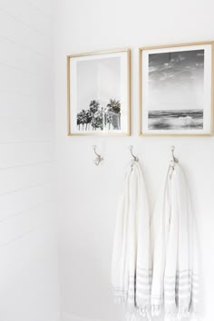 two pictures hanging on the wall next to each other in a bathroom with white walls