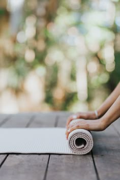 a person is doing yoga on a mat outside with their hands resting on the edge