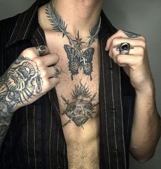 a shirtless man with tattoos on his chest holding a ring and looking at the camera