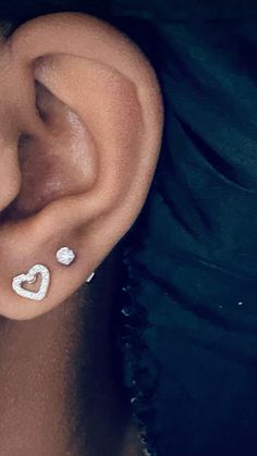 a close up of a person's ear with two piercings on it and one behind the ear