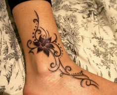 a woman's foot with a flower tattoo on it