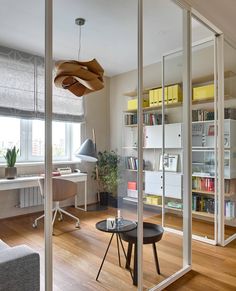 a living room filled with furniture next to a window covered in bookshelves and shelves