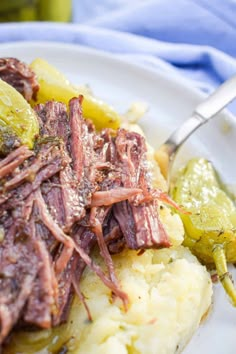 a white plate topped with meat and potatoes