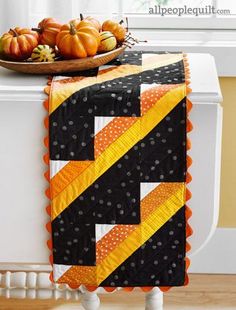 a quilted table runner with pumpkins on it