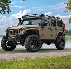 a jeep parked on the side of a road near water