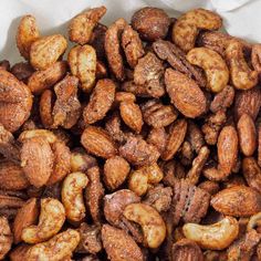 a pile of roasted nuts sitting on top of a white table cloth covered in brown sugar