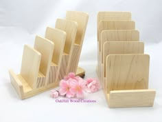 a set of wooden business cards and pen holders with pink flowers in the foreground