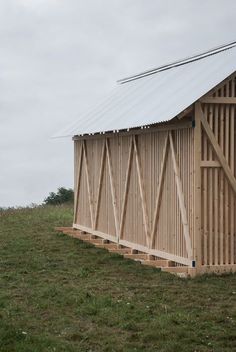 the side of a building with wooden slats on it's sides and a metal roof