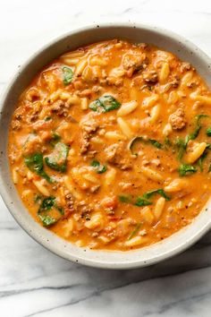 a white bowl filled with pasta and meat soup