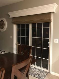 a dining room table and chairs with sliding glass doors