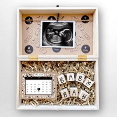 an open box with letters and pictures on the inside that spell out baby's name