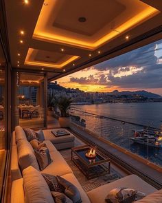 a living room filled with lots of furniture next to a large window overlooking the ocean