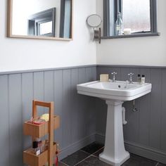 a white pedestal sink sitting under a bathroom mirror