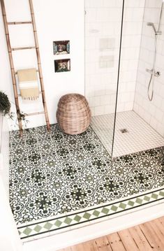 a bathroom with a tiled floor, shower and wooden ladder in the corner next to it