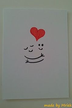 a white card with a red heart on it and a drawing of a smiling face