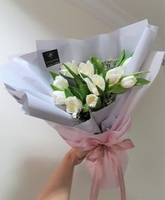 a person holding a bouquet of white flowers