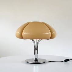 a lamp that is sitting on top of a white table with a black cord attached to it