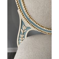 an upholstered chair with blue and gold trimmings on the armrest