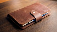 a brown leather wallet sitting on top of a wooden table