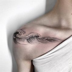 a woman with a wave tattoo on her shoulder