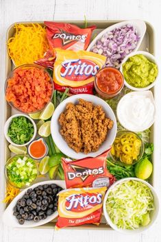 a tray filled with taco salad ingredients and condiments