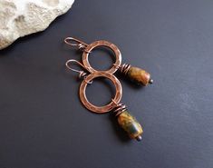 Hammered copper earrings. Hoop earrings. Red creek jasper earrings. Earthy colors earrings. Autumn earrings Rustic earrings. Bohemian earrings. Gemstone earrings. Ethnic earrings. Dangle hoop earrings. Artisan earrings. The copper parts of these earrings are hand-hammered and wax polished. They have a light flame patina. The ear wires are handmade from pure copper wire. ● Materials: Natural stone, Copper ● Measures: - Length- about 2.28 inches (5.8 cm) x 0.87 inches (2.2 cm). - Weight - about 4 Hammered Copper Earrings, Autumn Earrings, Hammered Jewelry, Rustic Earrings, Jasper Earrings, Dangle Hoop Earrings, Artisan Earrings, Fall Earrings, Ethnic Earrings