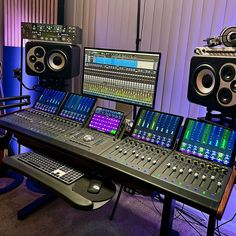 there are many sound mixing equipment on this table in the studio, and one is sitting next to another