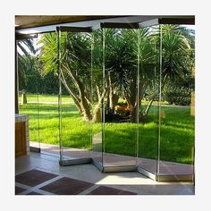 a room with glass doors that look out onto the grass and trees in the background