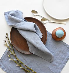 a plate with a napkin on top of it next to some spoons and forks