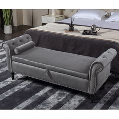 a gray couch sitting on top of a rug next to a white and black bed