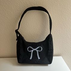 Urban Outfitters X Baggu Exclusive Mini Black Nylon Shoulder Bag With Embroidered Blue Bow Questions? Leave A Comment Below! Baggu Bags, Embroidered Bow, Nylon Shoulder Bag, Blue Bow, Black Nylon, Black Bag, Black Nylons, Tote Bag Design, Black Blue