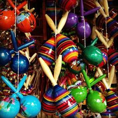 an assortment of colorful balls and sticks hanging from the ceiling in a store or shop