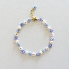 Blue flower bracelet with pearls Daisy flower bracelet for women  Freshwater pearl bracelet Gold Filled Jewelry Dainty Handmade Bracelet 24k gold plated brass chain and clasp. To determine your exact wrist/ankle size, get a tape measure! The bracelet is made of light blue and white Czech beads size 10/0 (about 2mm diameter), freshwater pearls measuring about 4mm and a 24k gold plated clasp and extension chain. Cute and delicate daisy bracelet with pearls will add a light touch to your casual and holiday outfits! Lobster clasp and extender for length adjustment and easy removal. Bracelet Pearl Ideas, Pearl Beads Bracelet, Rice Pearl Jewelry, Self Made Bracelets, Flower Bead Bracelet Tutorial, Homemade Jewelry Bracelets, Pearl Bracelet Ideas, Blue And Gold Jewelry, Cute Beaded Bracelets