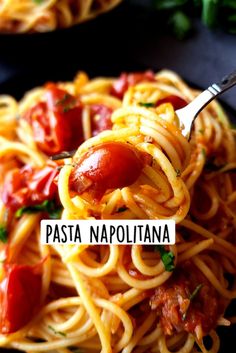 pasta with tomatoes and meat is served on a black plate