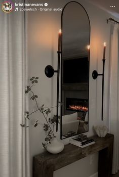 a mirror sitting on top of a wooden table next to a fireplace in a living room