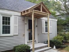 a small gray house with a porch attached to it