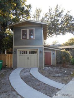 two garages are shown in front of a house with trees on the other side