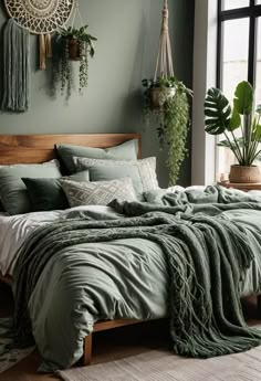 a bed in a bedroom with green walls and plants hanging on the wall above it